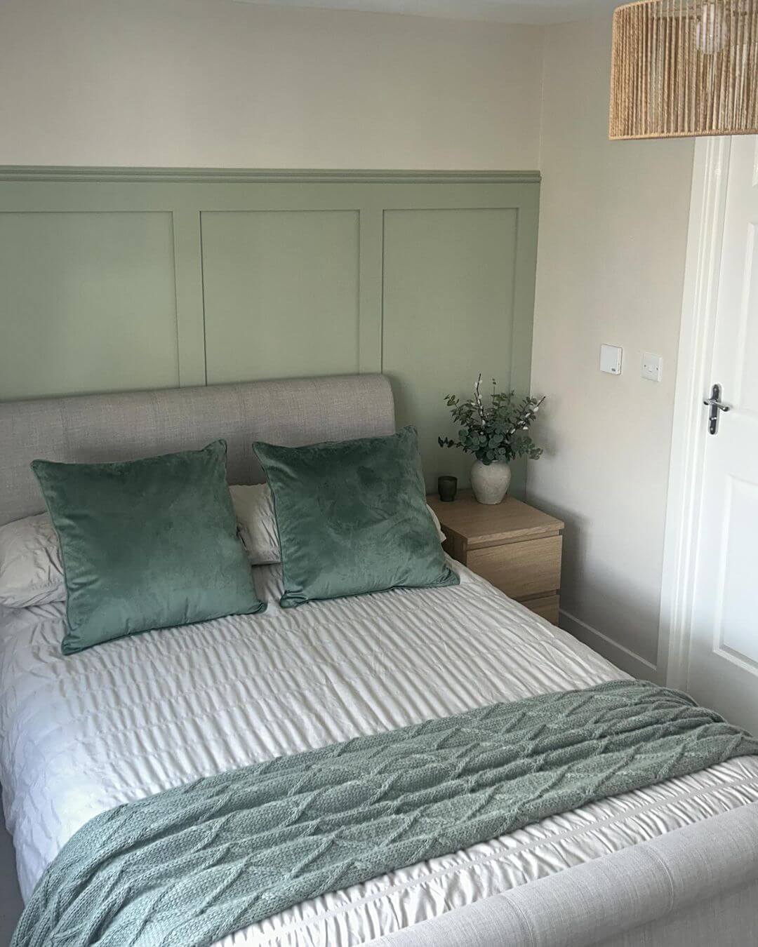 Sage green paneling creates a calming, textured backdrop
