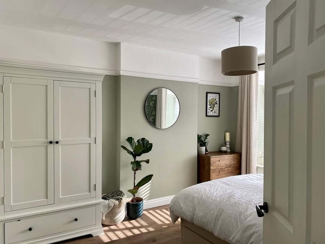 Balance Sage Green Walls with a Round Mirror and Art