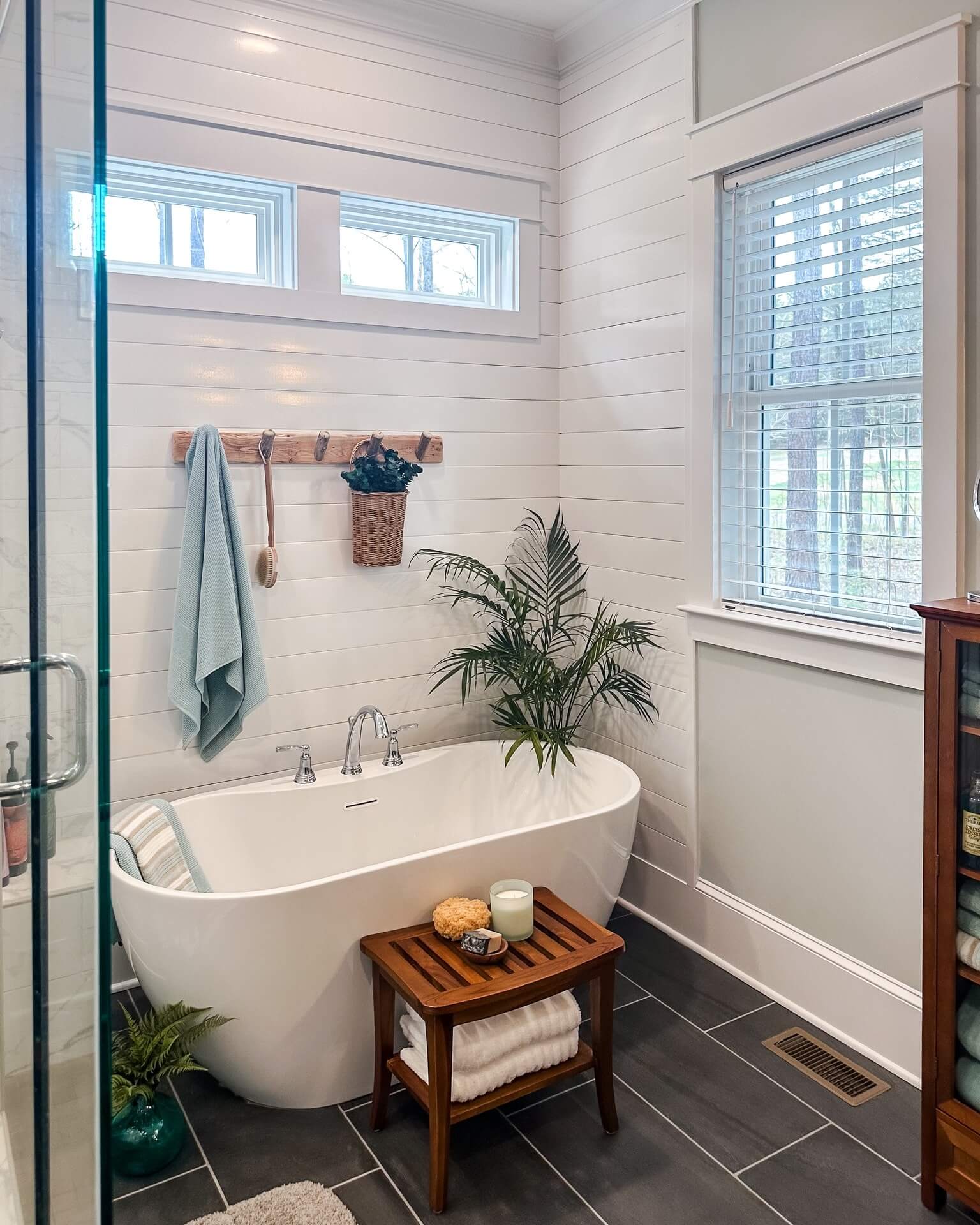 Wooden Peg Rack Holds Towels and Greenery Near Tub