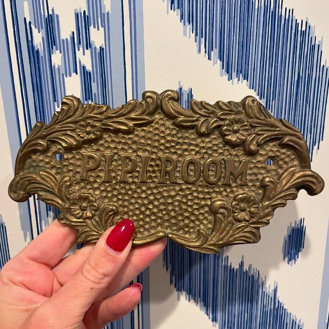 Ornate Brass Sign Adds Vintage Charm to a Powder Room