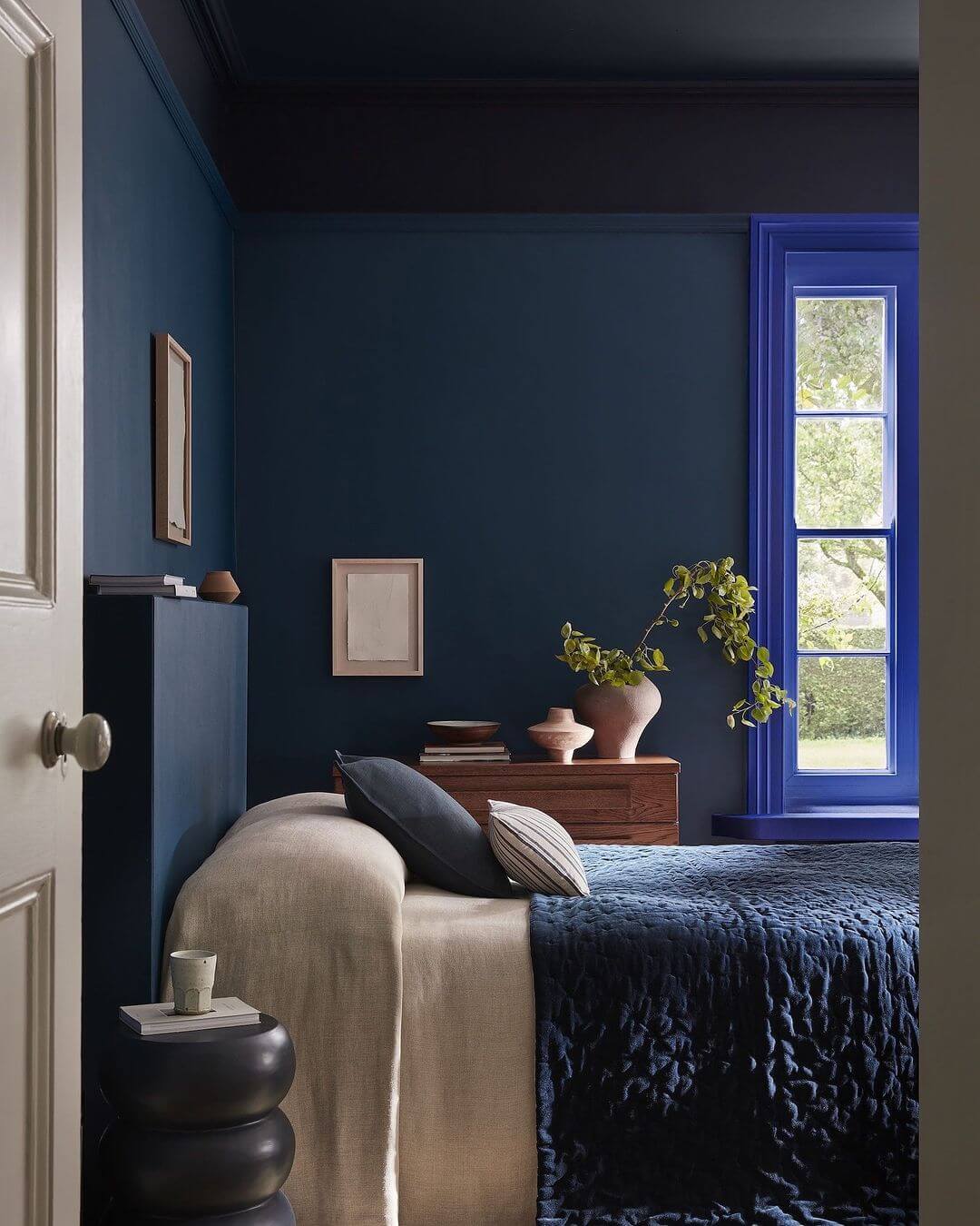 Dark Blue Window Frame Pops Against Deep Walls