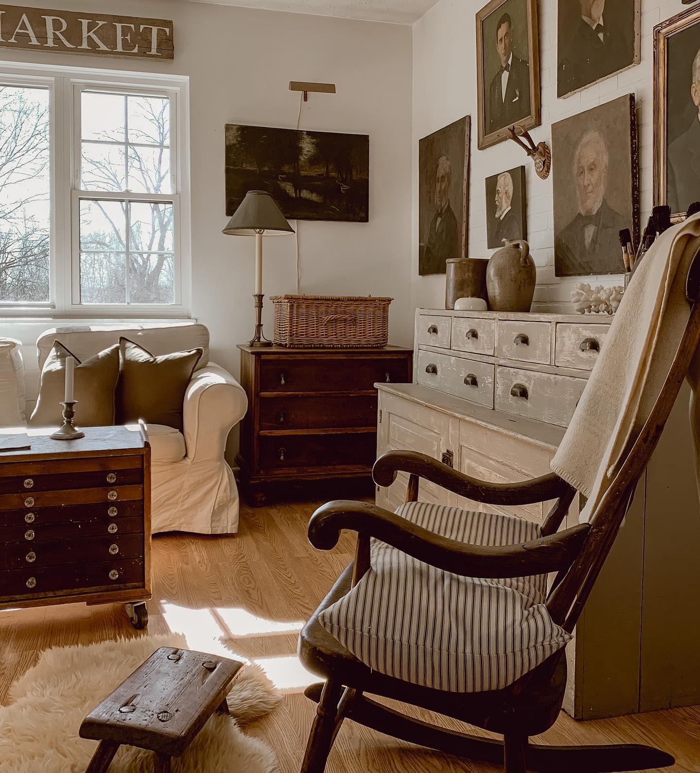 Antique Portraits Create a Gallery Wall Above a Distressed Dresser