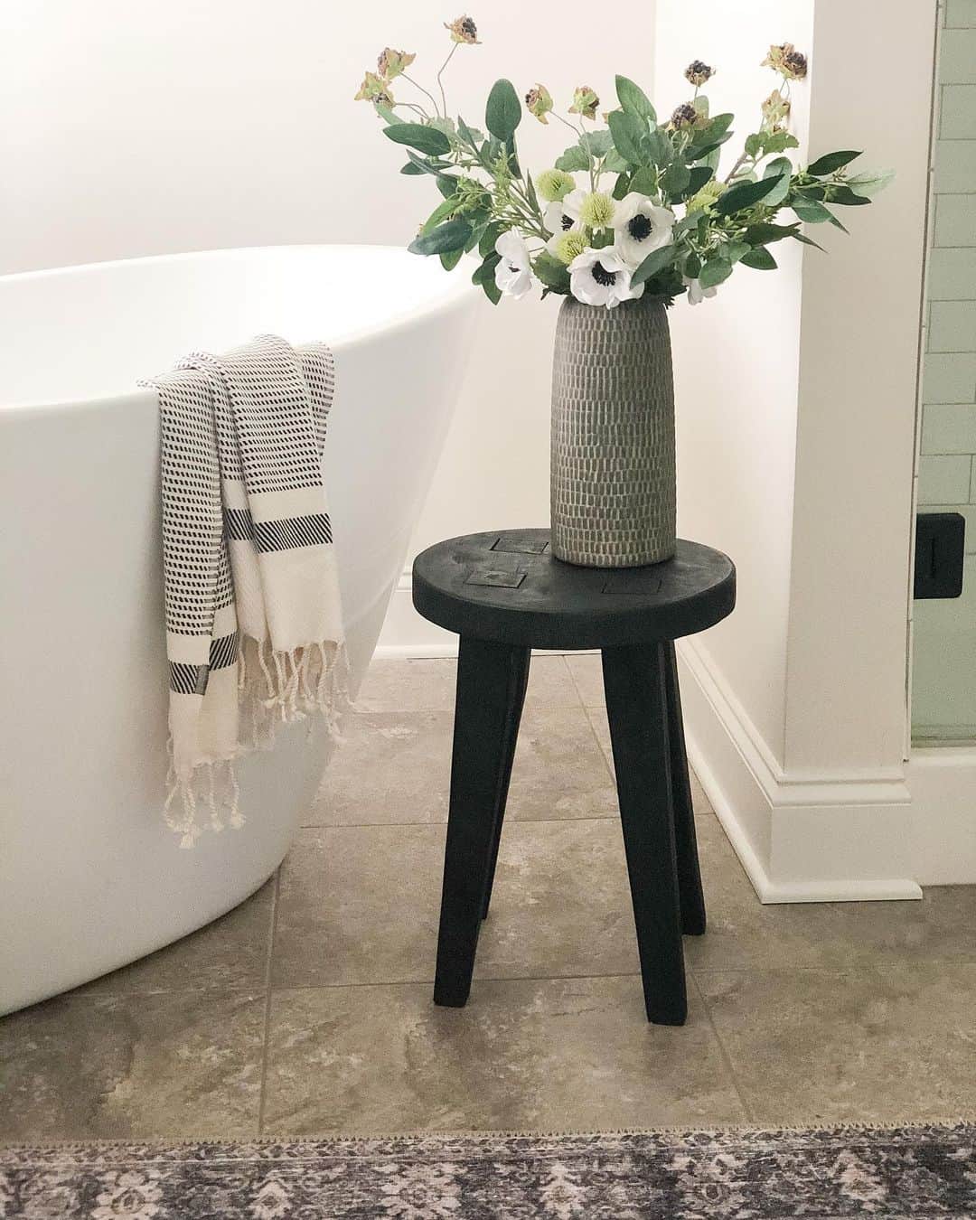 Black Stool as a Base for a Tall Textured Vase