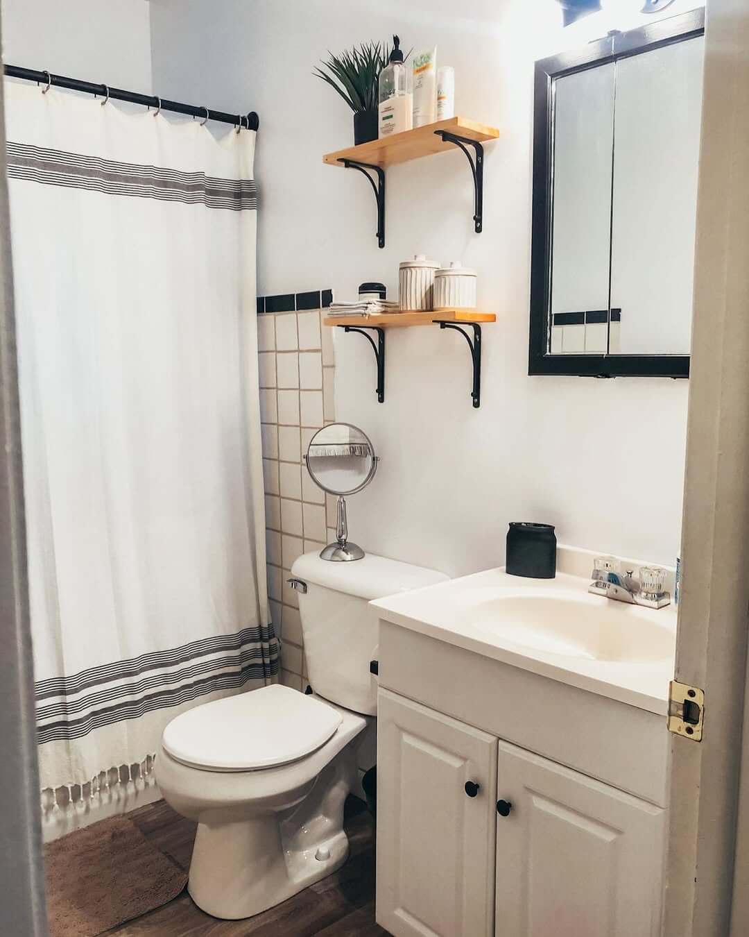 Wooden Shelves With Black Brackets Hold Toiletries and Greenery