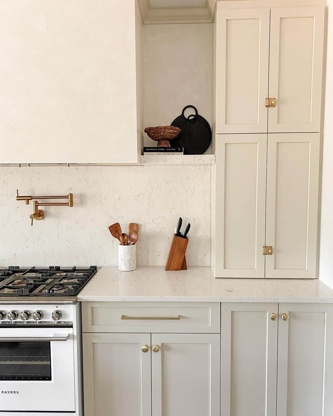 Warm Beige Cabinetry with Brass Hardware Adds Subtle Polish