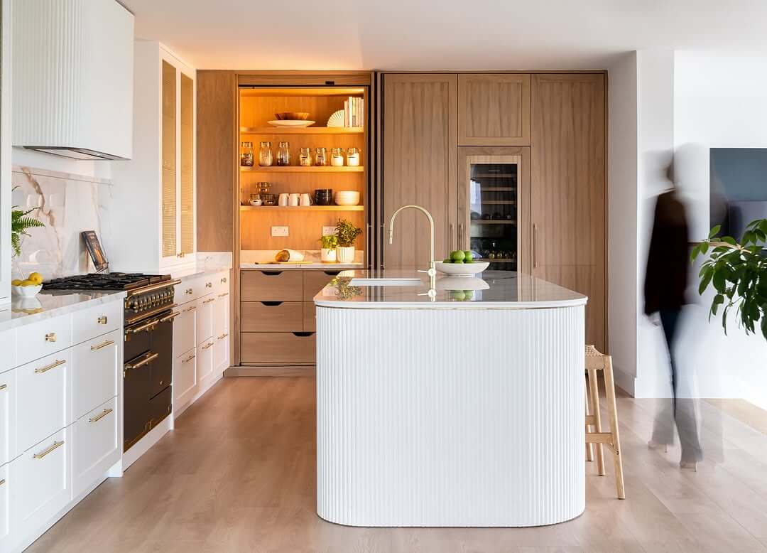 Fluted White Island Adds Soft Texture to Wood Kitchen