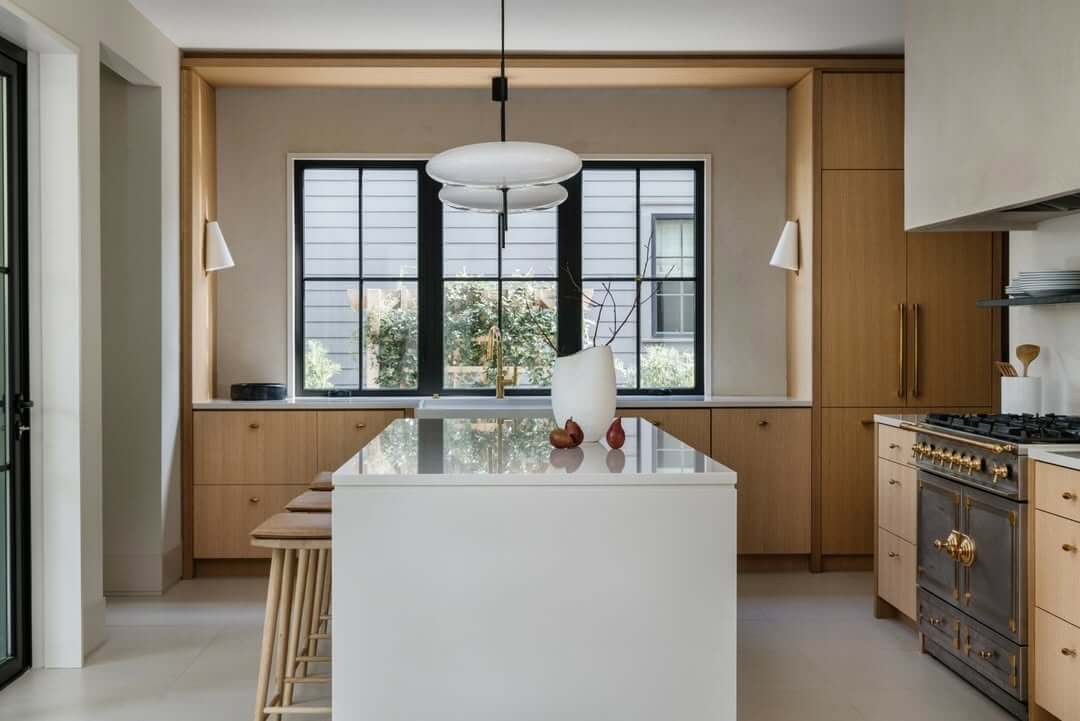 Warm White Oak Cabinets Frame a Dramatic Dark Range