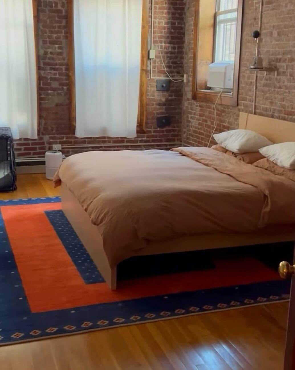 Bold Orange and Blue Rug Defines the Bed Area
