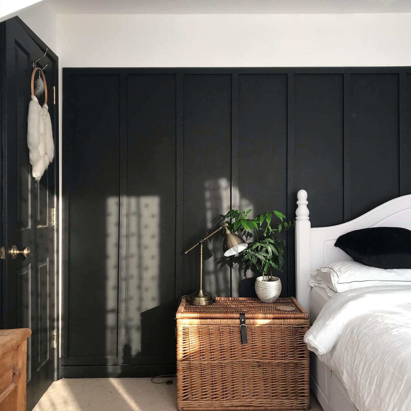 Paneled Black Wall with Woven Trunk Storage