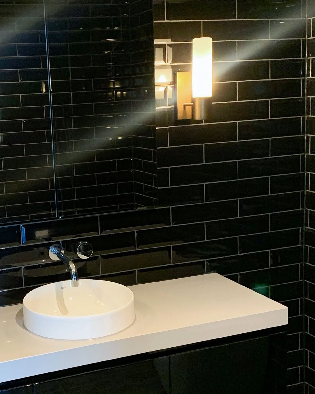 Glossy Black Subway Tiles Create a Sleek Vanity Backdrop