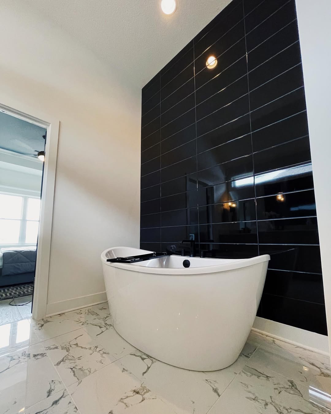 Glossy Black Subway Tiles Create a Dramatic Bathing Niche