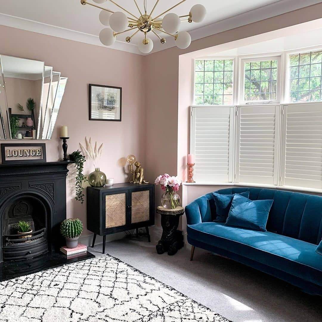 Art Deco Mirror Adds Glamour Above Black Fireplace