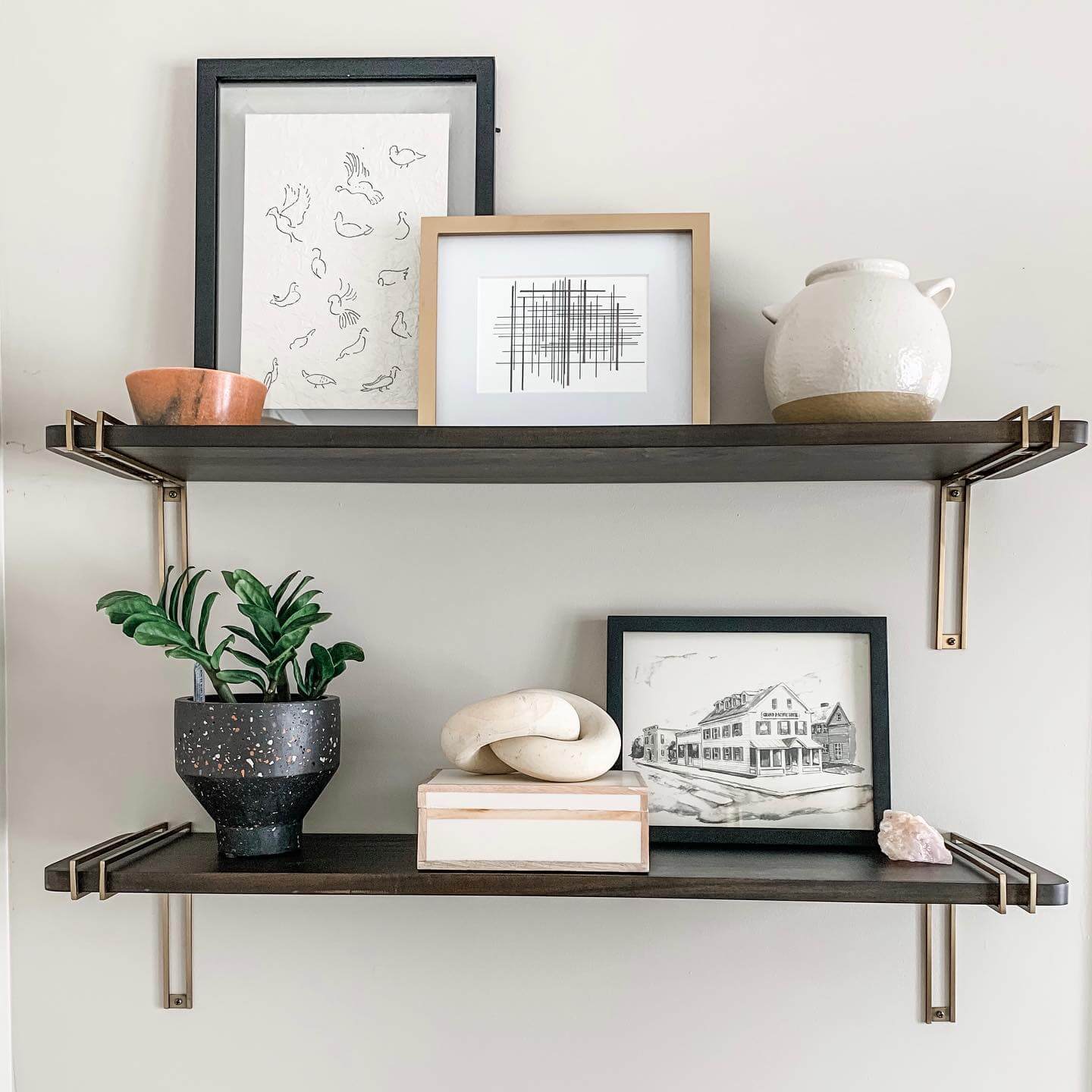 Layered Art and Objects Create Depth on Dark Shelves