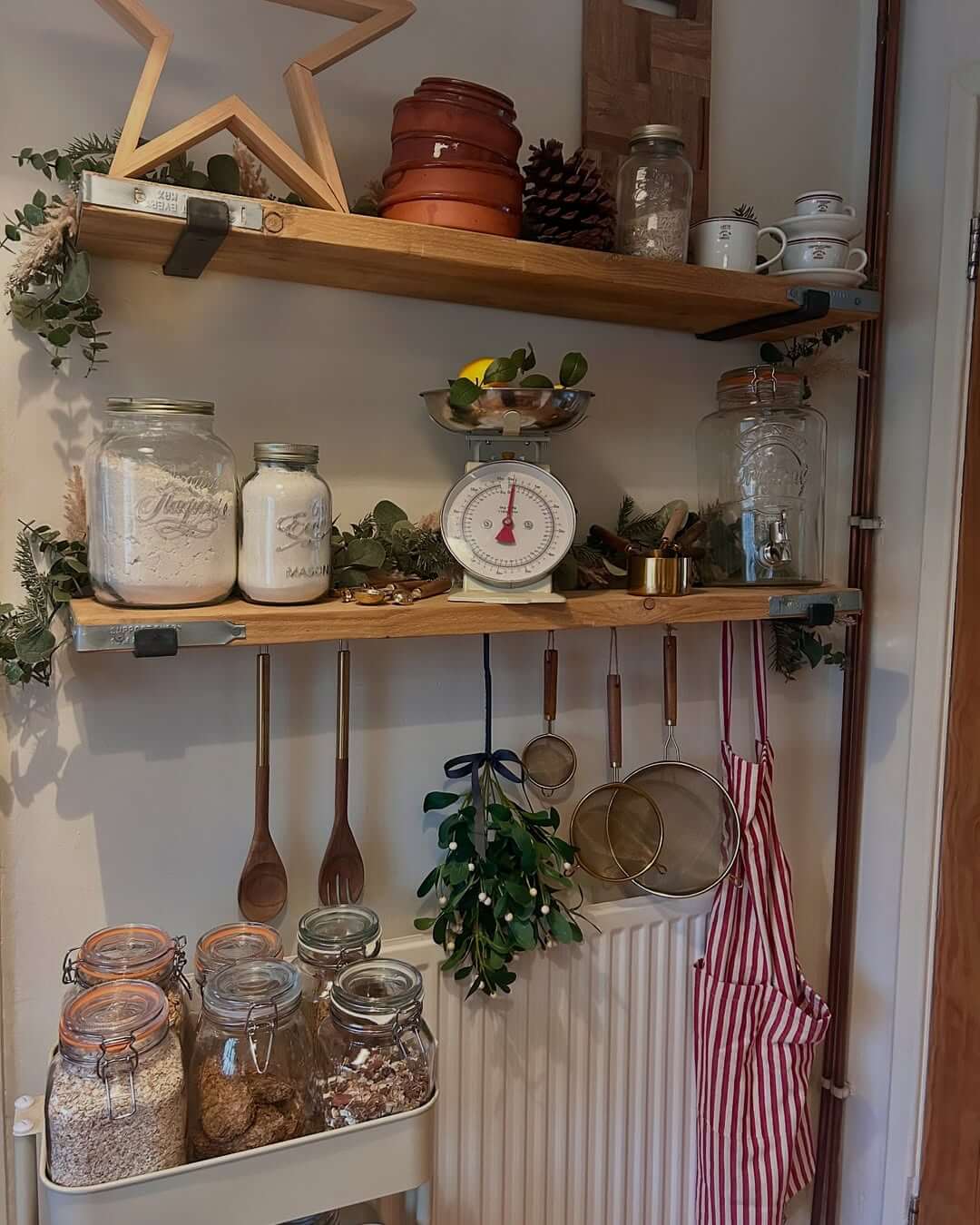 Wooden Utensils Hang From Hooks Below Open Shelving