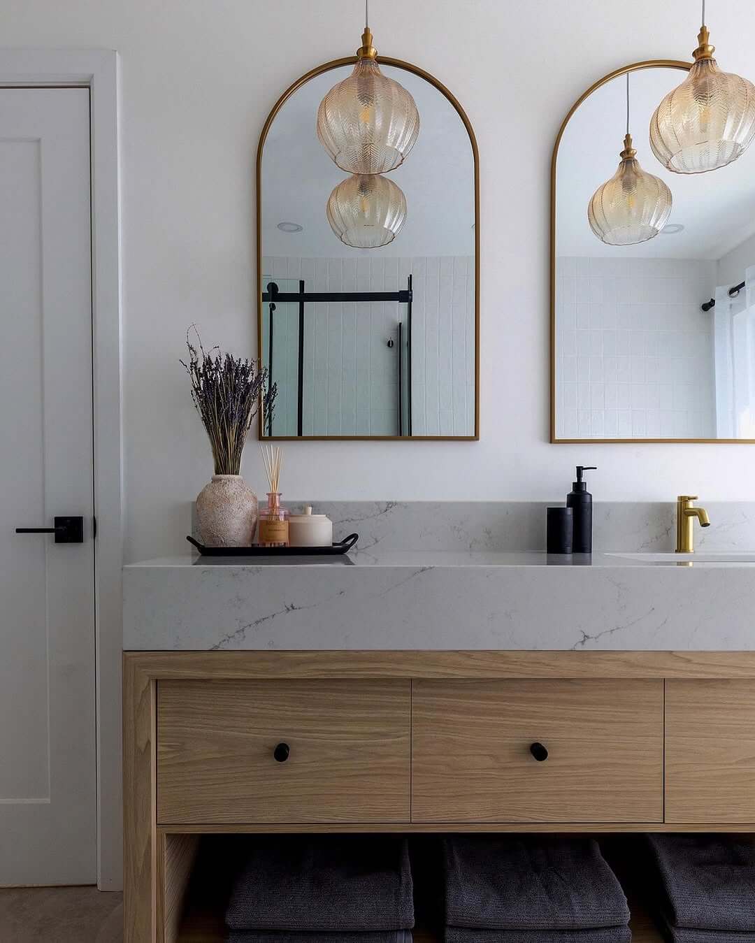 Arched Mirrors and Pendant Lights Frame the Vanity
