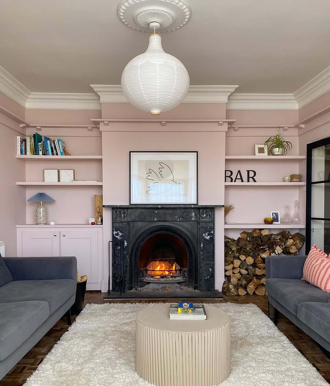 Stacked Firewood Adds Rustic Texture to Pink Room