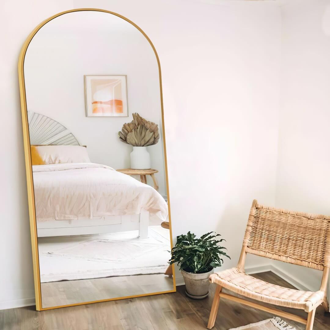 Arched Gold Mirror Reflects a Serene Bedroom Vignette