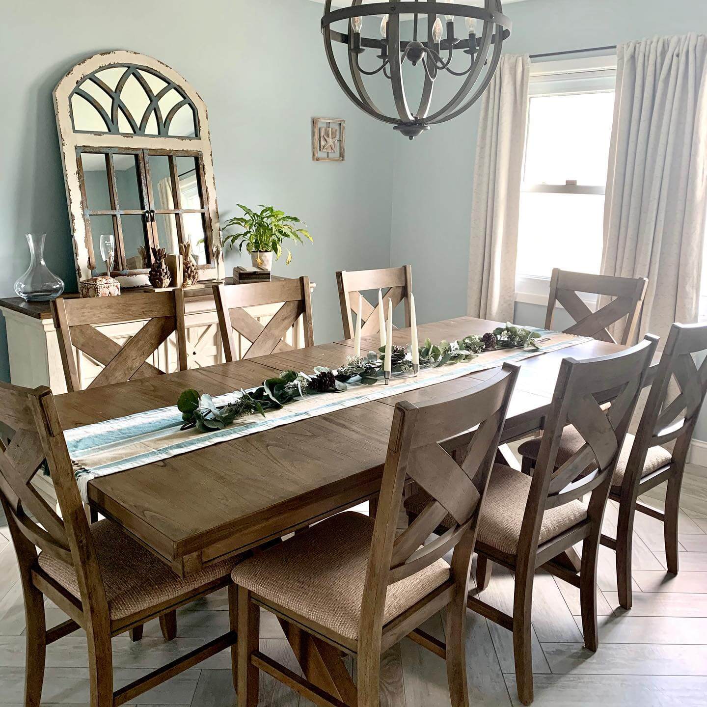 Arched Mirror Reflects Light Above a Distressed Buffet