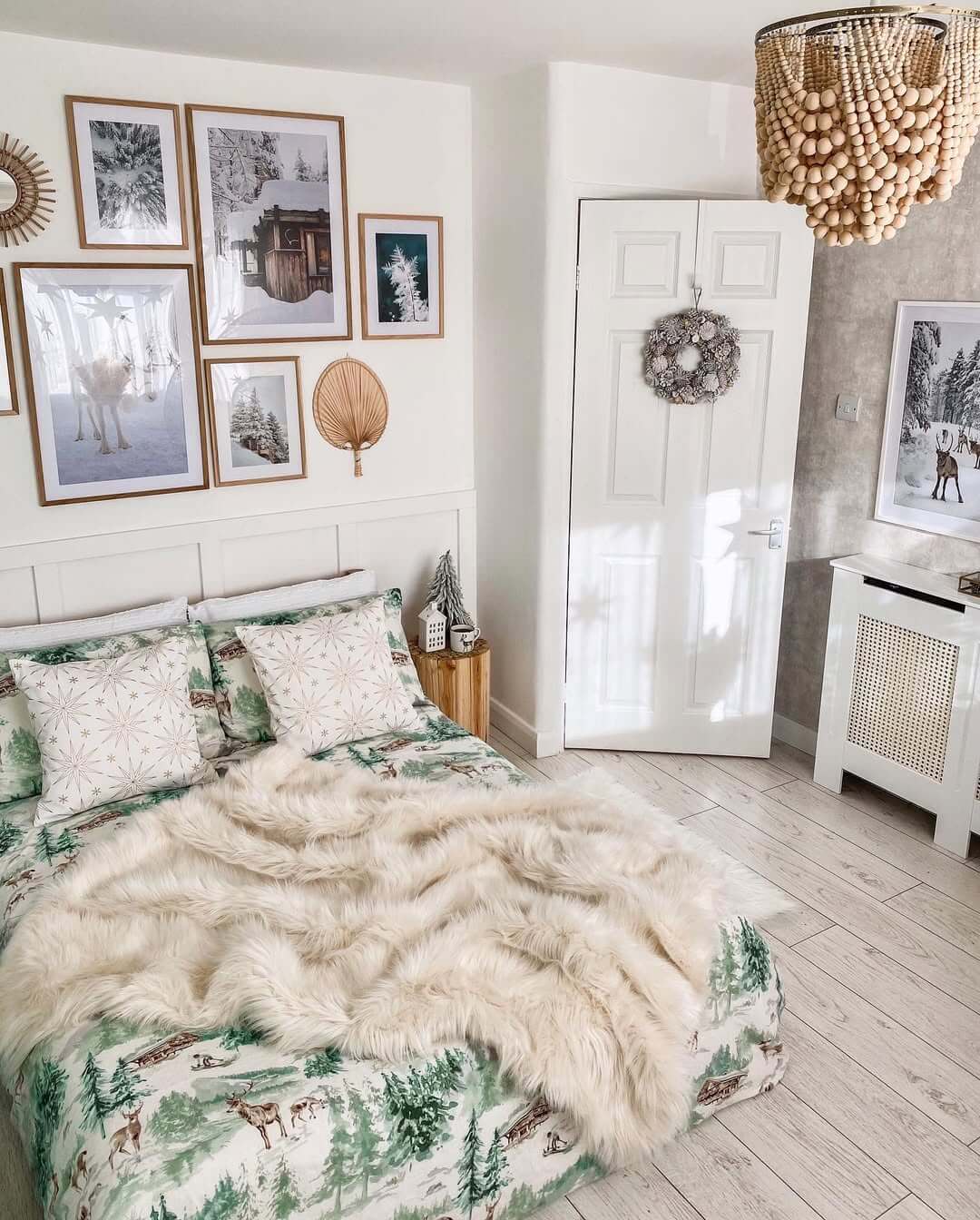 Gallery Wall of Winter Scenes Adds Cozy Charm Above the Bed
