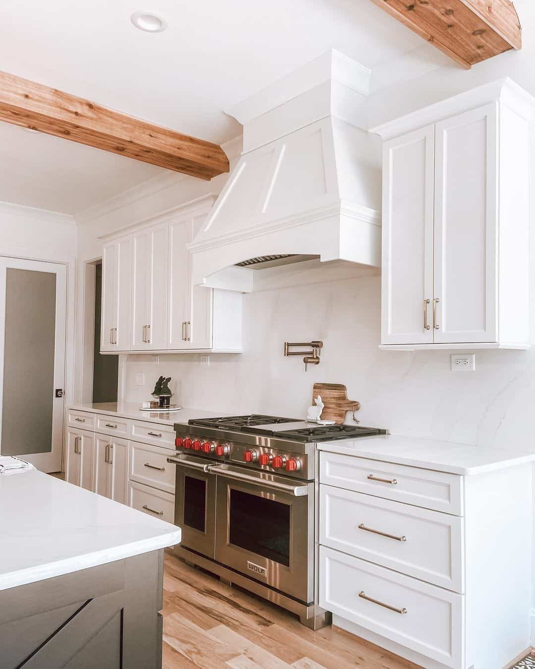 Exposed Wood Beams Frame a Clean White Kitchen