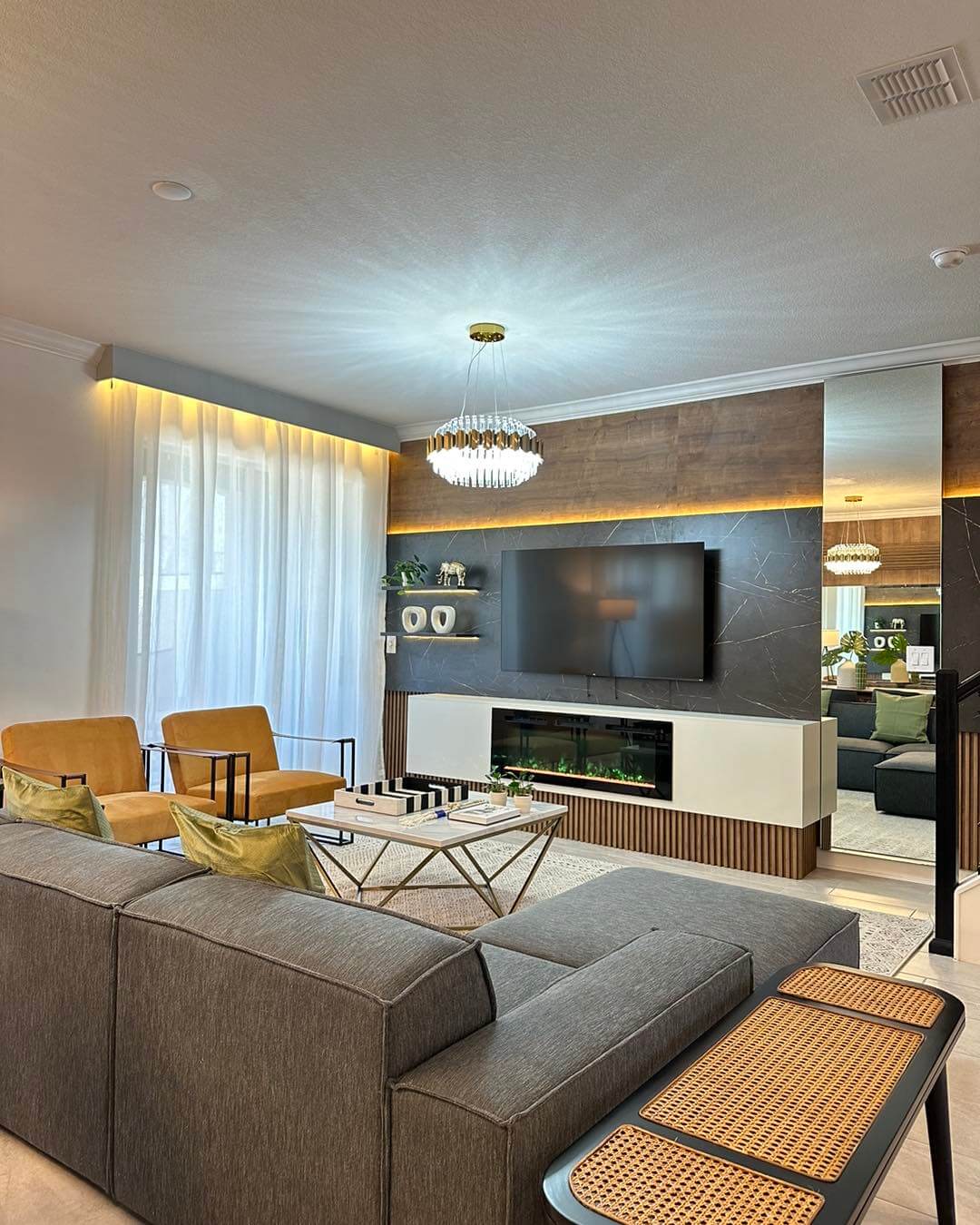 Layered wood and marble wall panels create a dramatic media backdrop