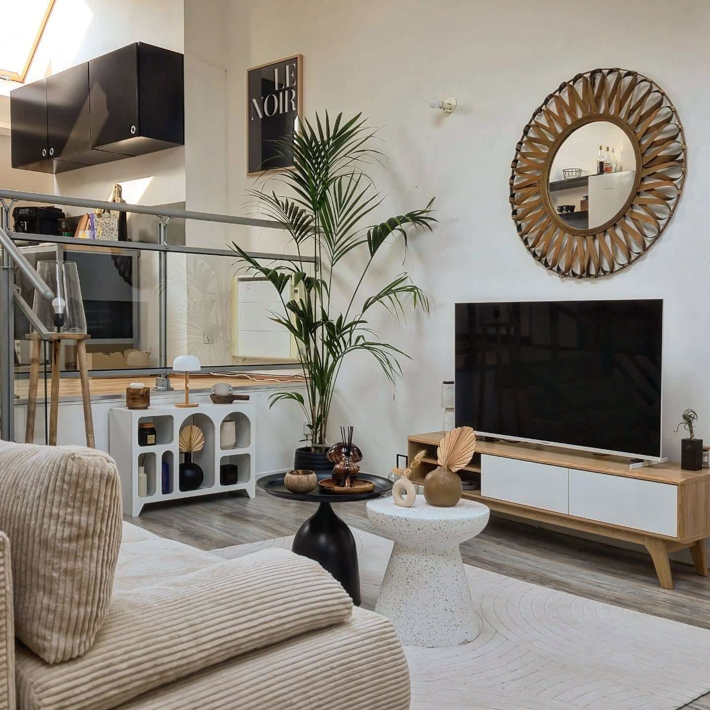 Sunburst mirror frames the television with natural texture