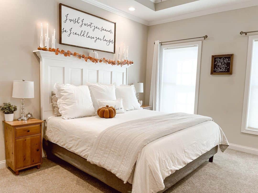 White Headboard Frames a Cozy Bed Topped with a Pumpkin Pillow