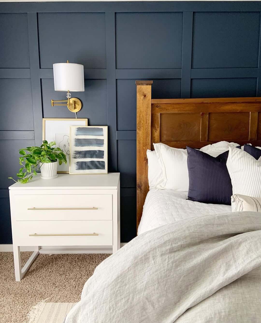 Dark Navy Grid Paneling Creates a Moody Bedroom Backdrop