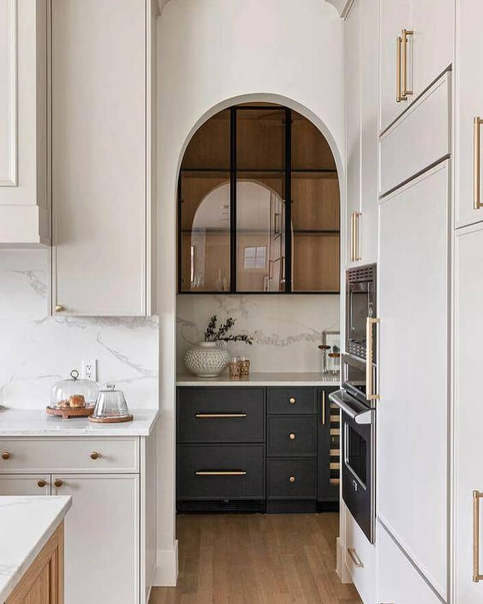 Arched Glass Cabinetry With Dark Mullions for a Dramatic Display