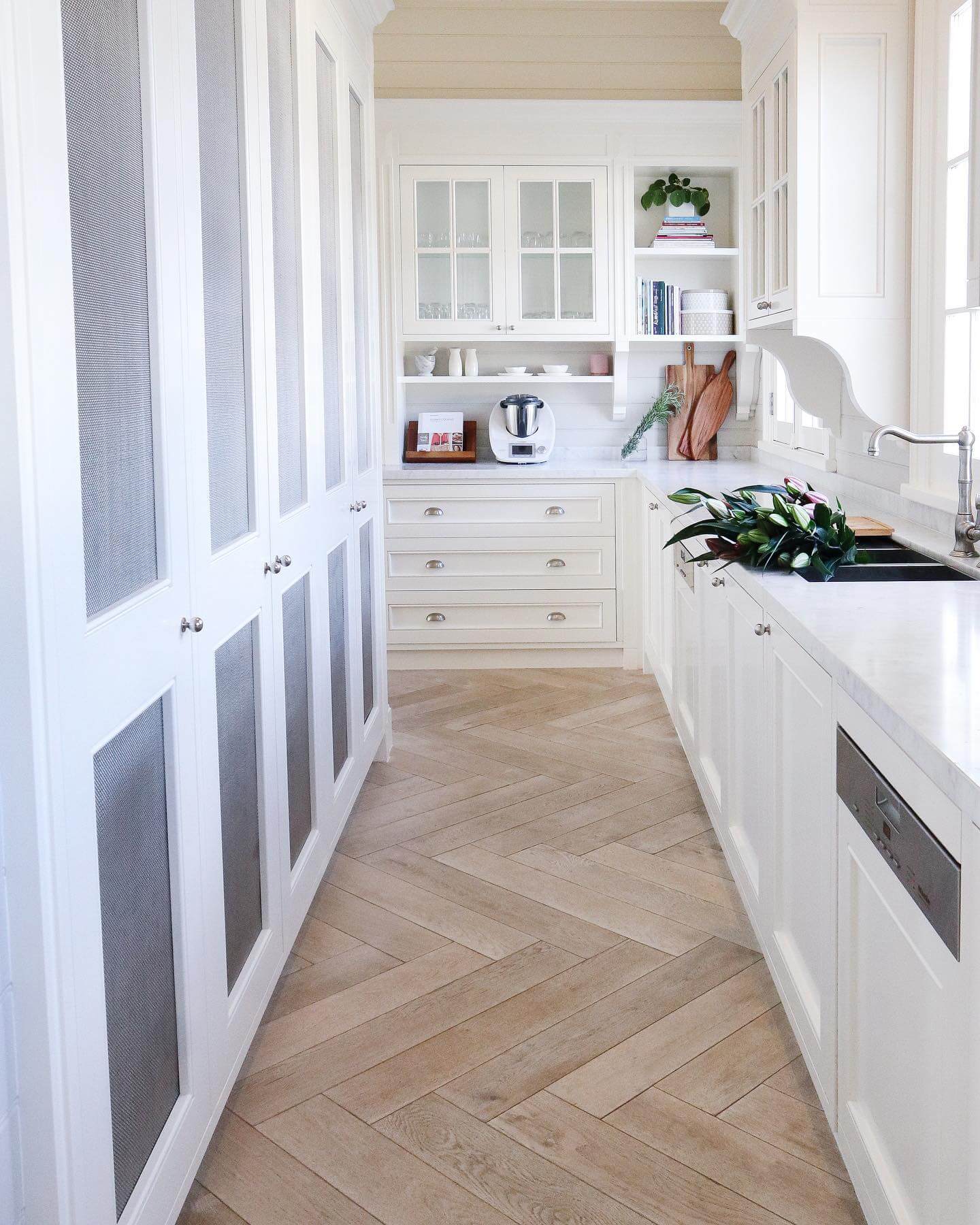 White cabinetry with mesh inserts offers a subtle textural detail