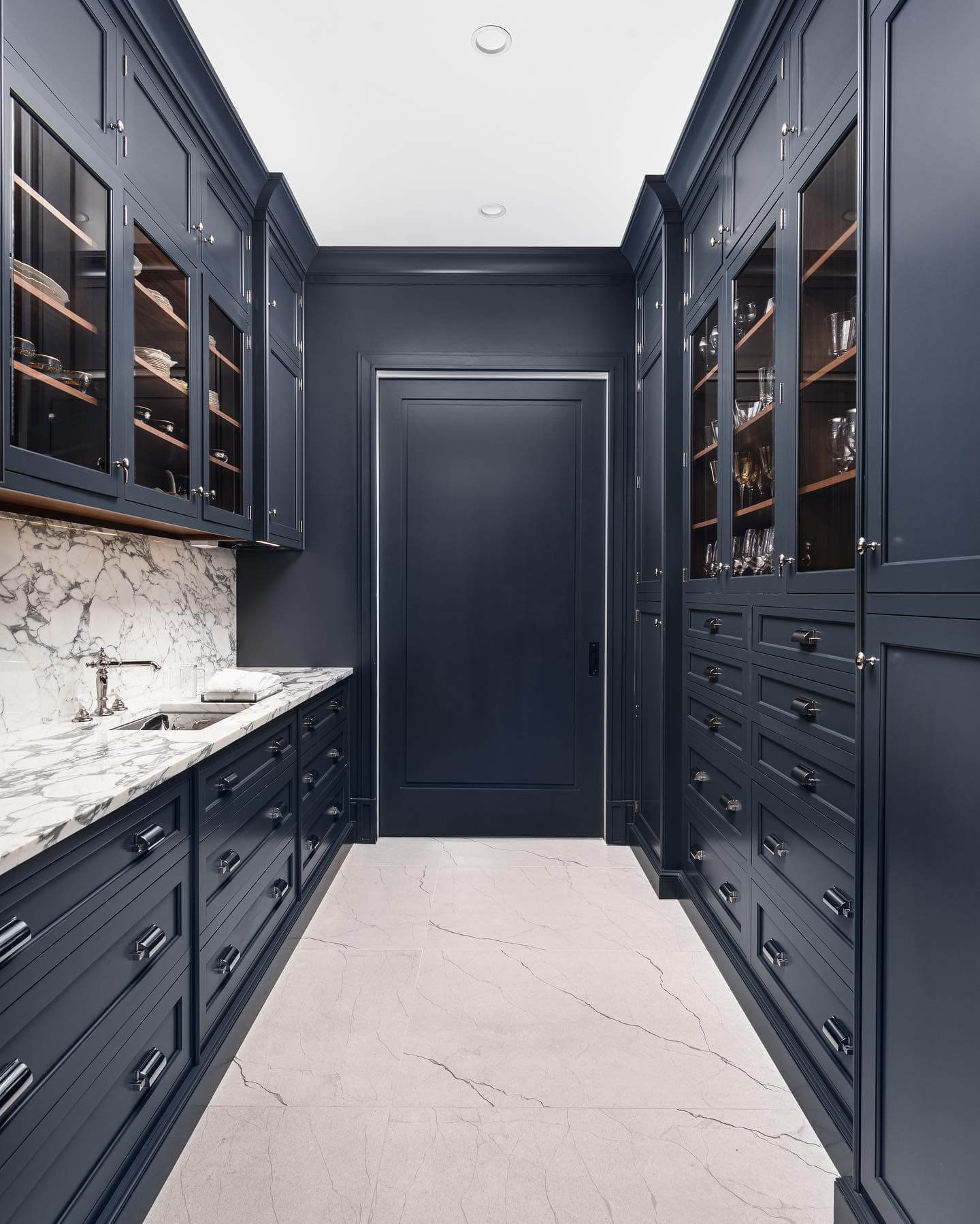 Glass-fronted cabinets display glassware and dishware