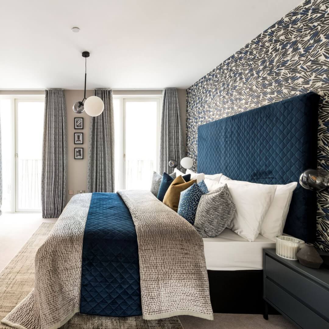 Diamond-Tufted Navy Headboard Frames a Bold Patterned Wall