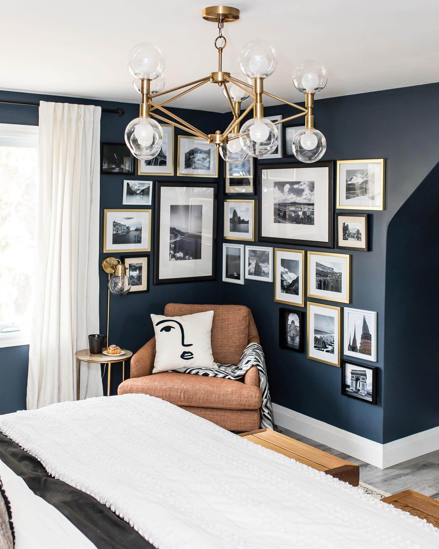 Gallery Wall Mixes Black and Gold Frames Above Navy