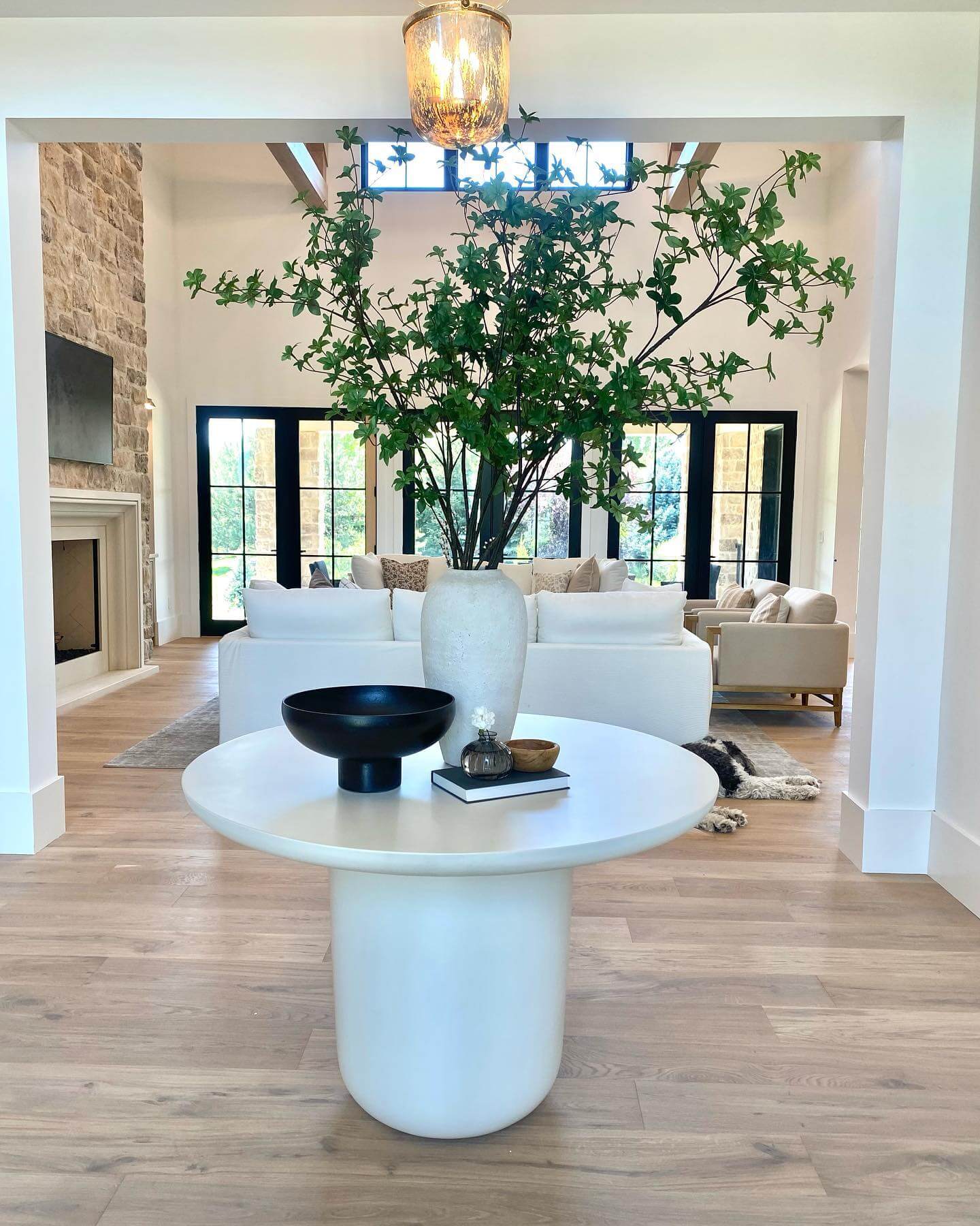 White Pedestal Table with Black Bowl and Tall Greenery