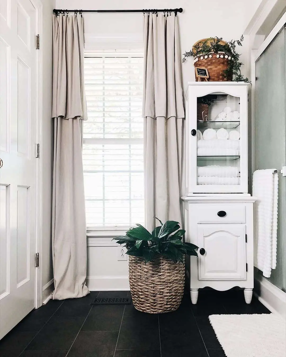 White Cabinet With Glass Doors Displays Rolled Towels