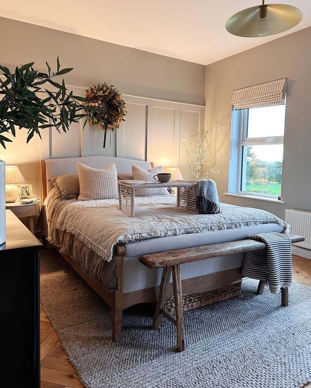 Dried floral wreath adds natural texture above the bed