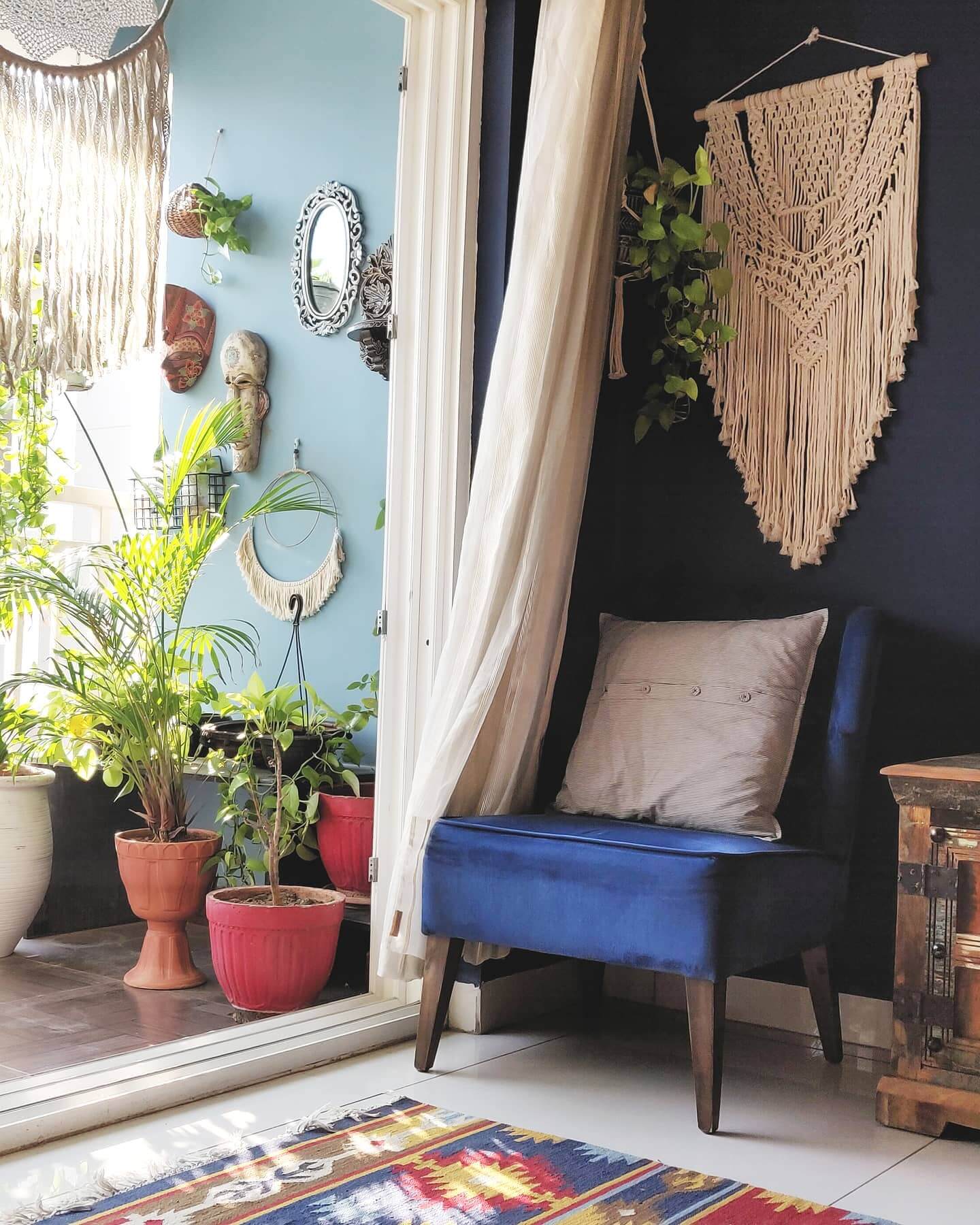 Macrame wall hanging adds boho texture above a velvet chair