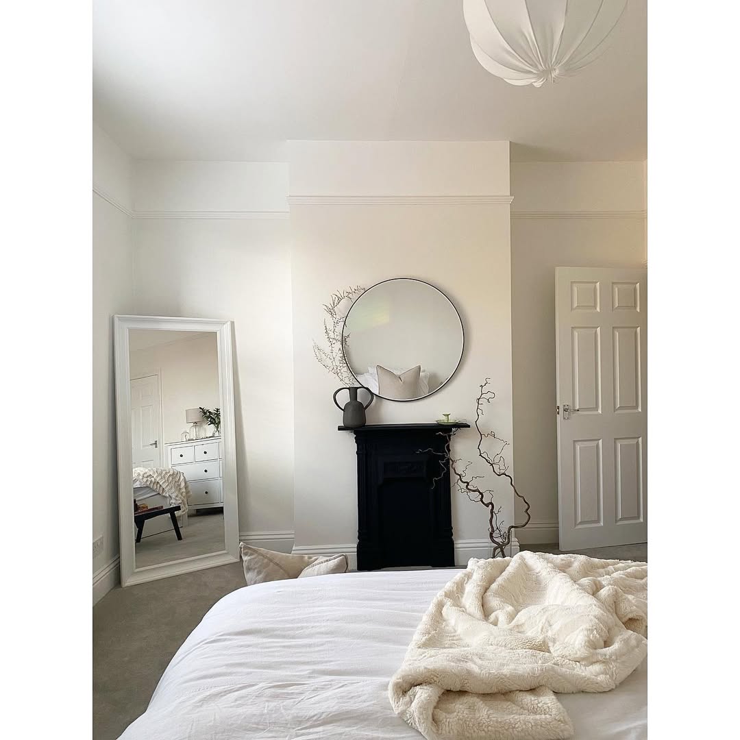 Round Mirror Above Black Fireplace Mantel