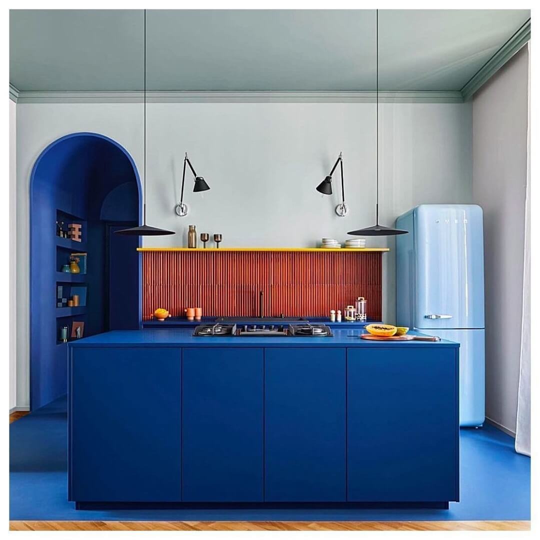 Contrast a Bold Blue Island with a Ribbed Red Backsplash