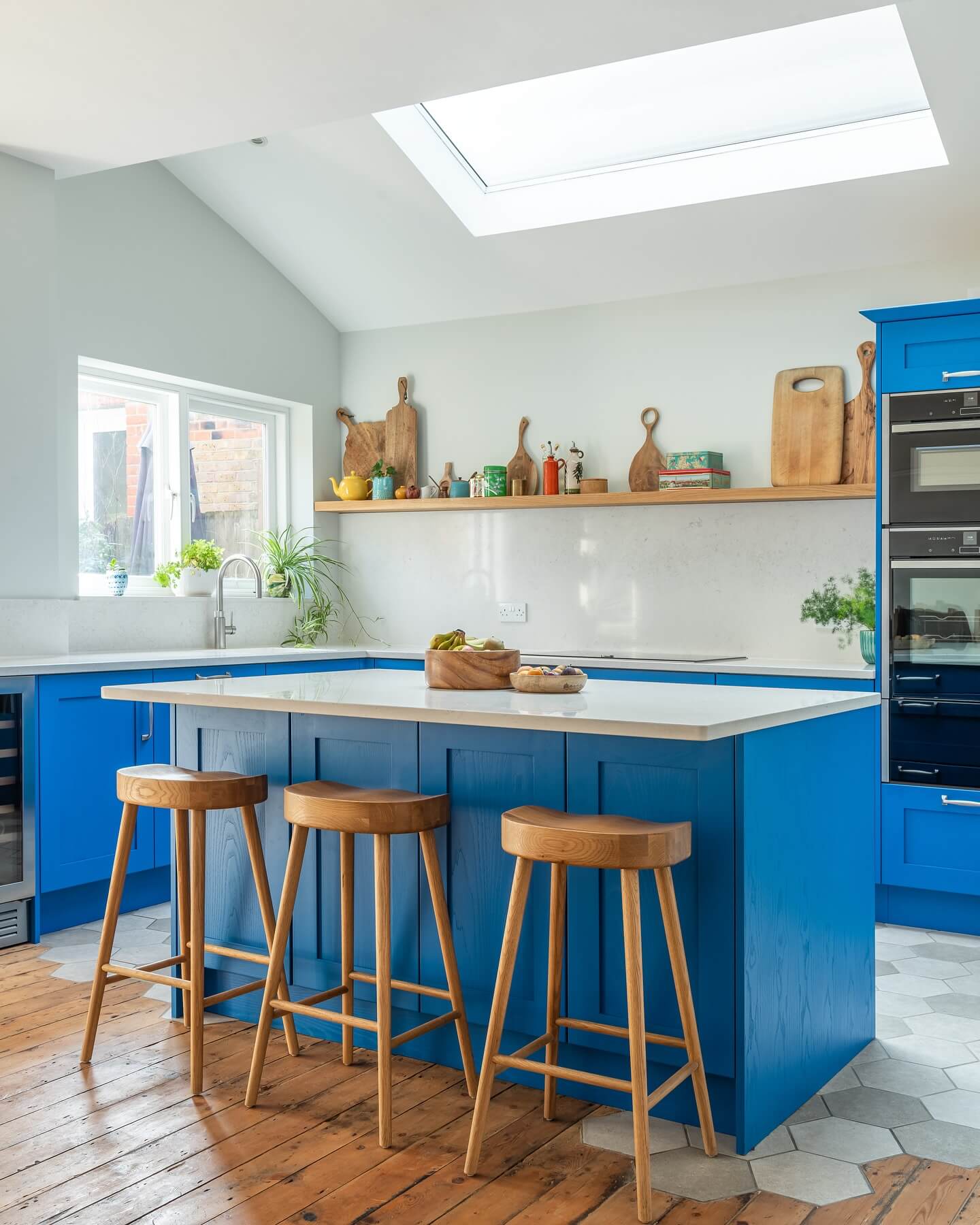 Wooden Stools Add Natural Warmth to Bold Blue Island