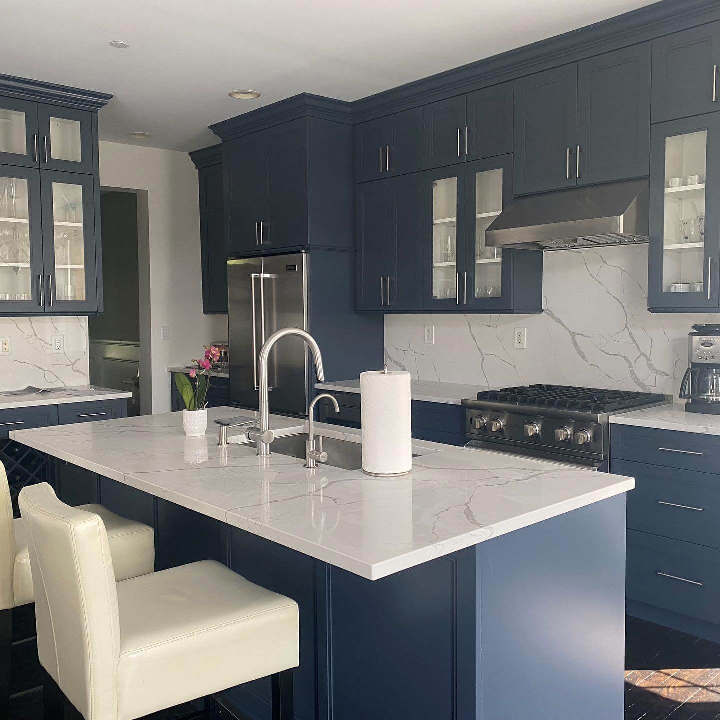 Contrast Deep Blue Cabinets with a White Marble Backsplash