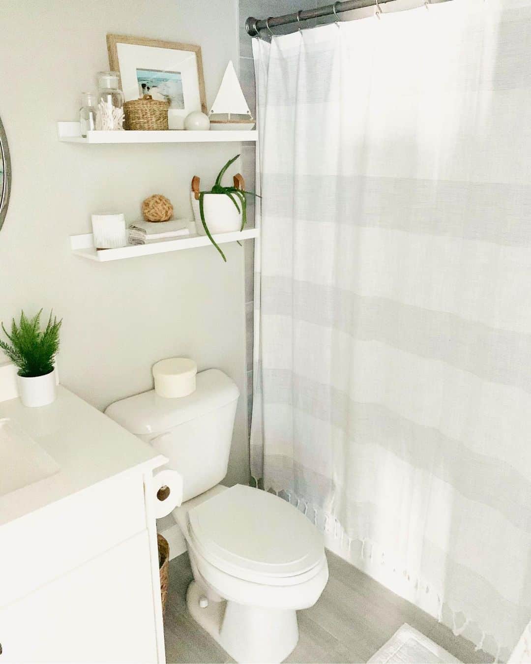 Floating Shelves Display Coastal Accents Above Toilet