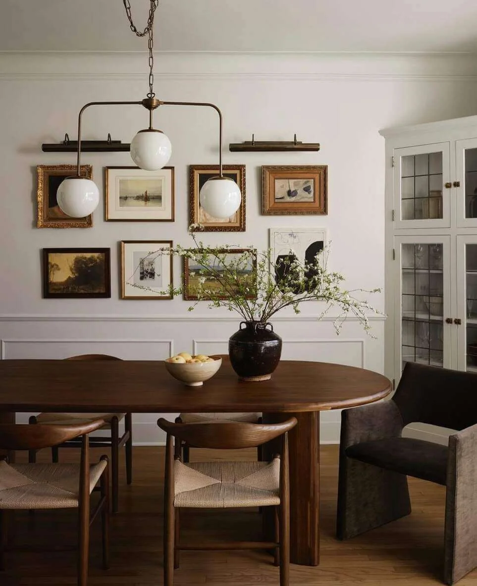 Gallery Wall of Vintage Art Anchors the Dining Space