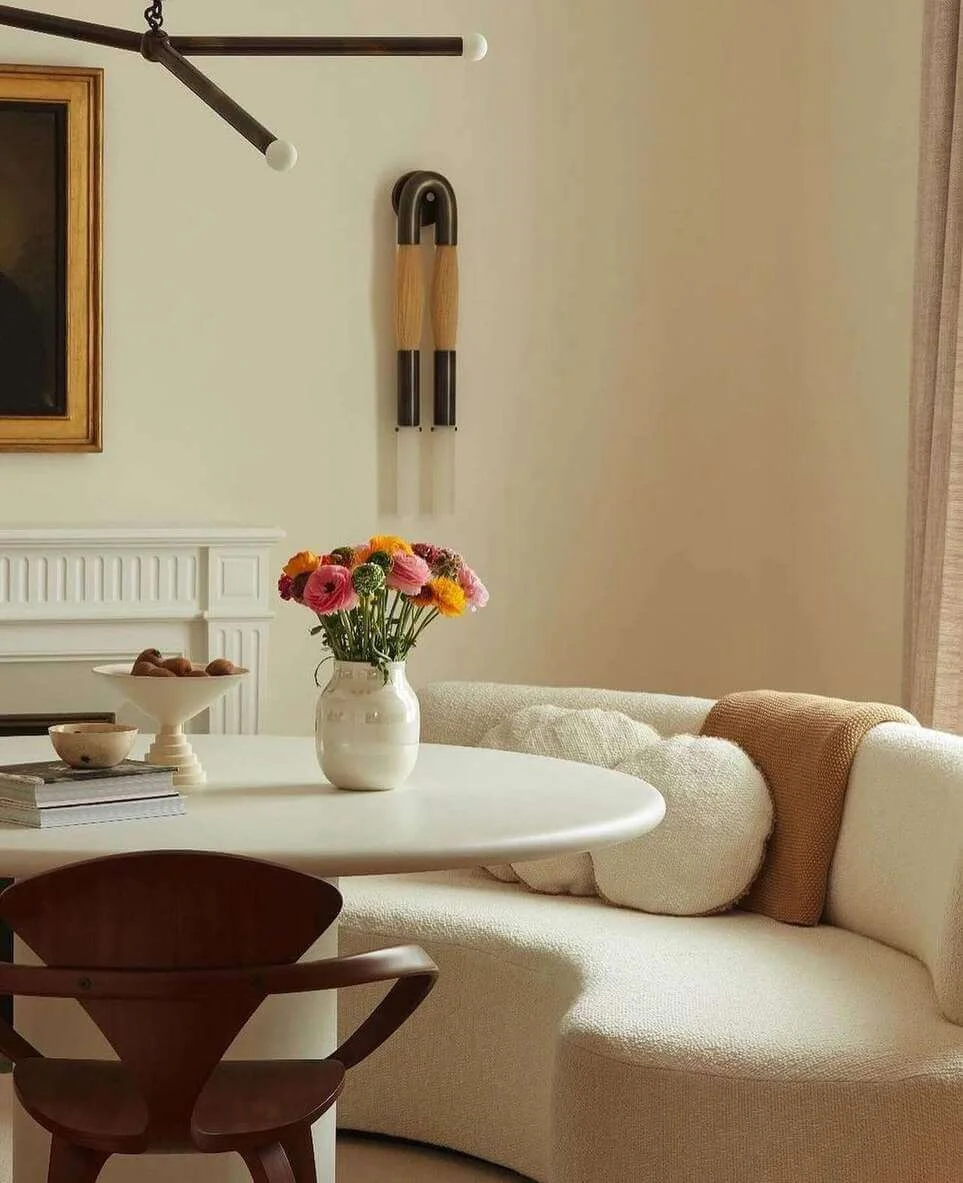 Round Dining Table with Sculptural White Vase of Flowers