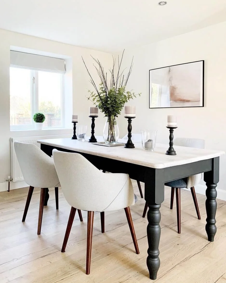 Tall Black Candlesticks Frame a Tall Vase of Greenery