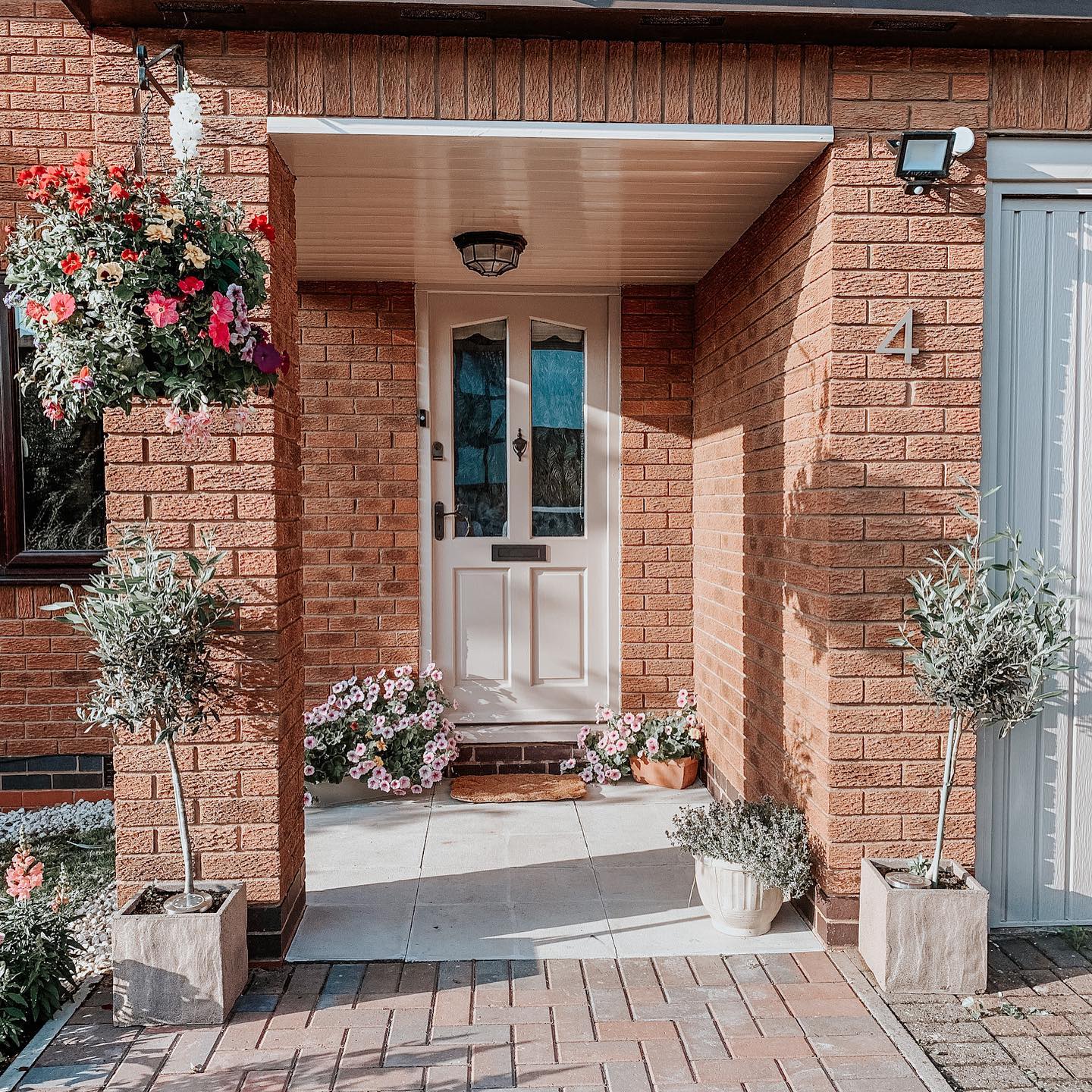 Frame Your Entryway with Hanging Baskets and Potted Trees