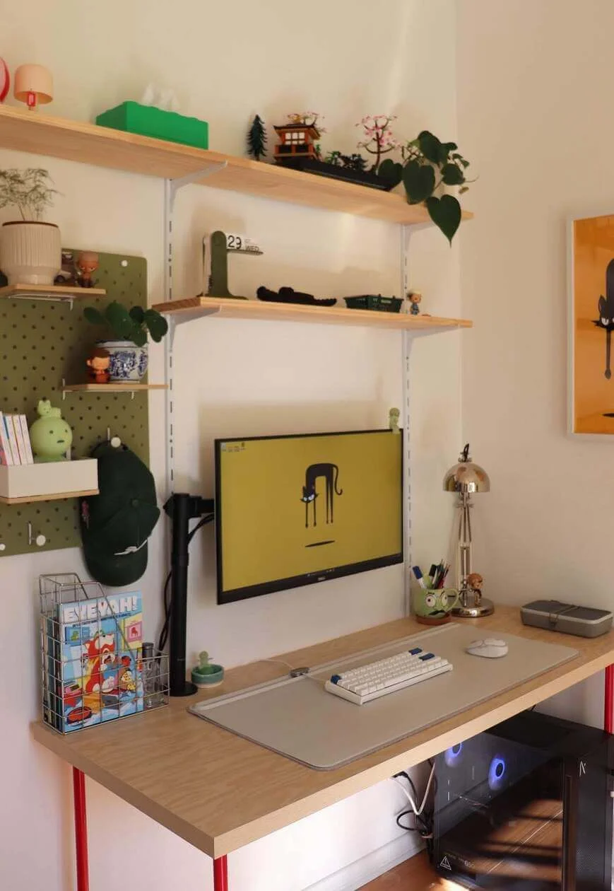 Sage green pegboard displays quirky figurines and plants
