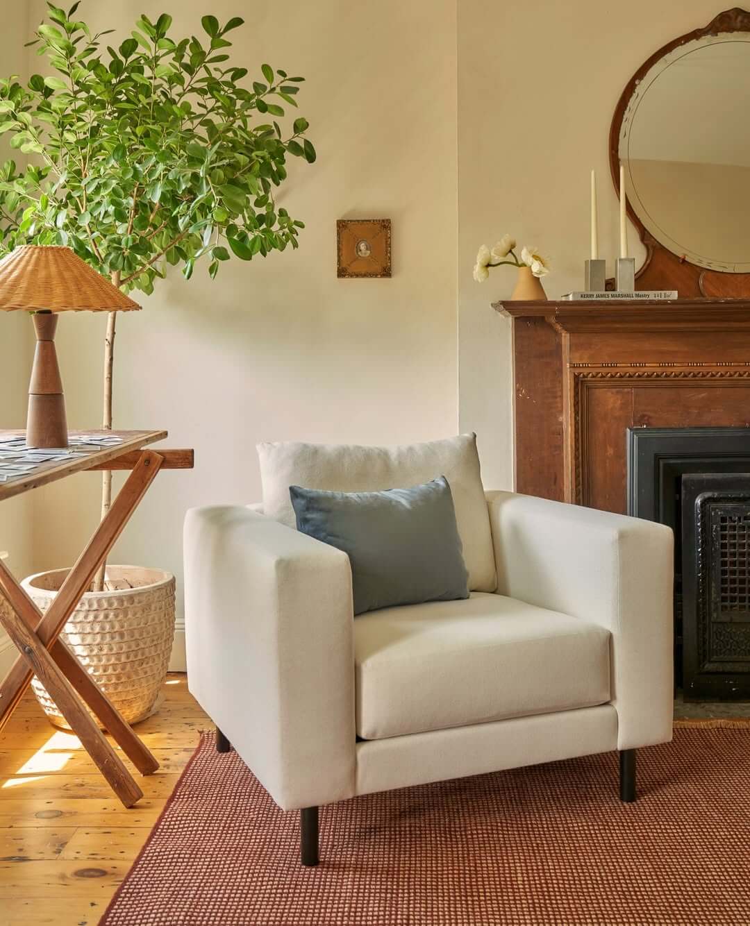 Cream Armchair Anchors a Corner With a Single Blue Pillow