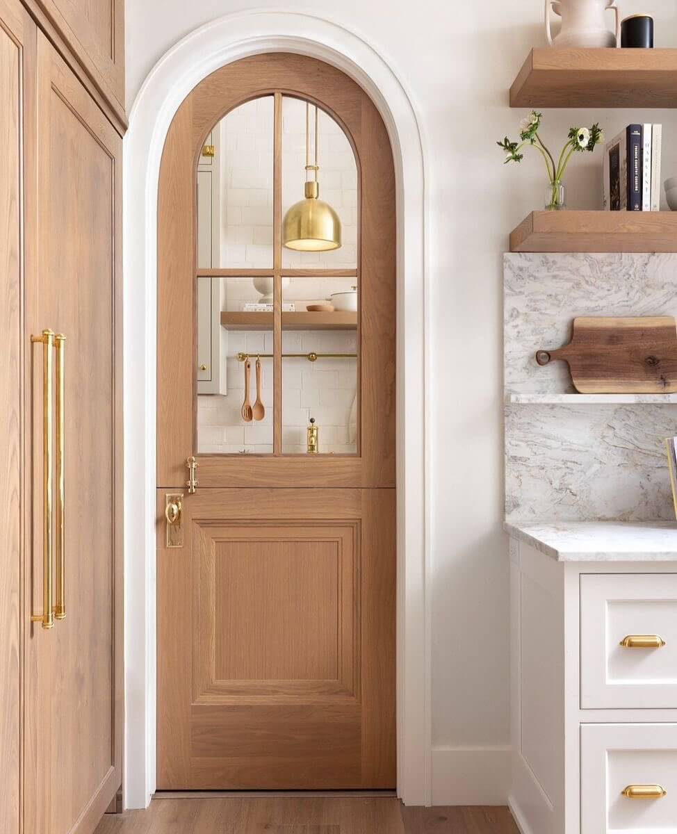 Arched Dutch Door with Warm Wood Tones and Brass Hardware
