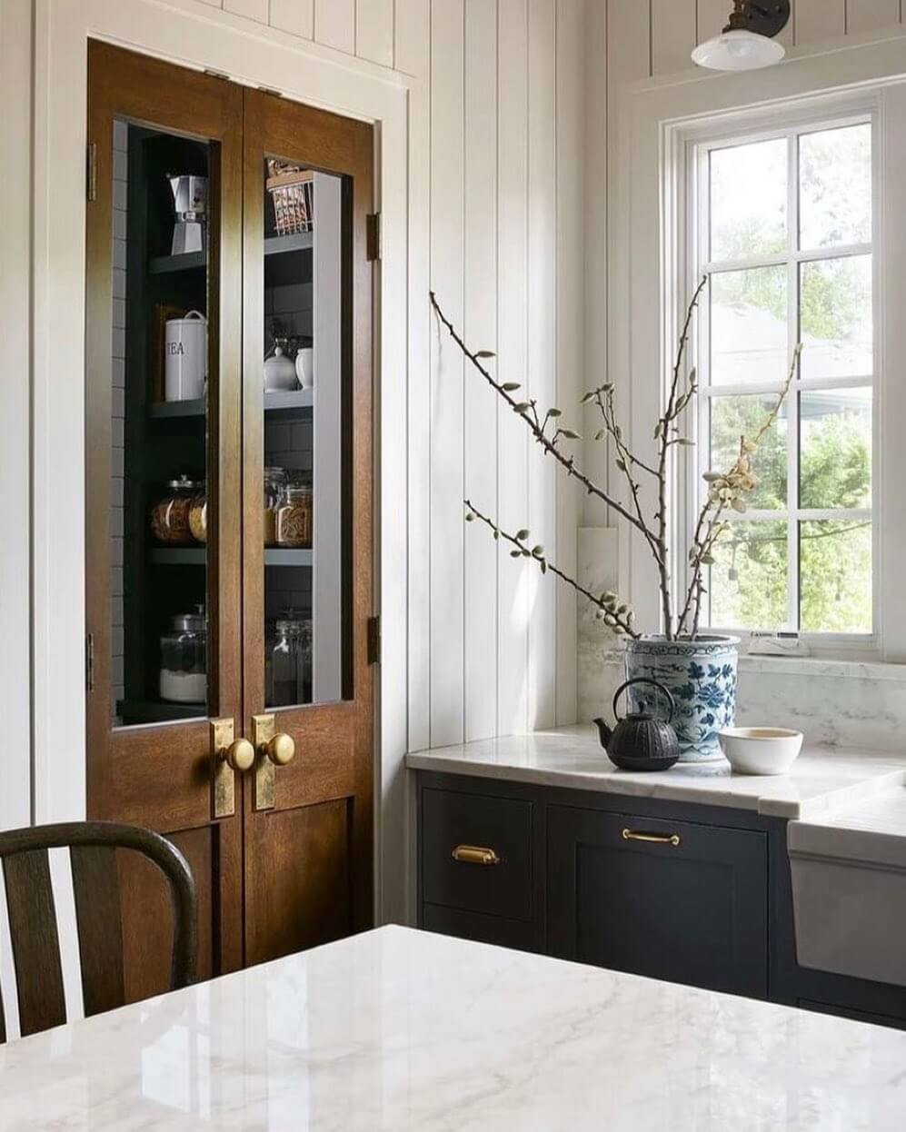 Warm Wood Pantry Doors With Brass Knobs